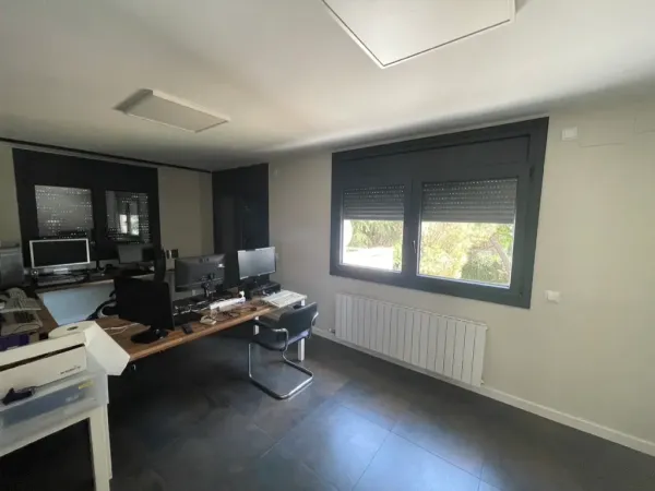 Imagen mostrando la integración de espacios tras una reforma integral en Cardedeu, con salón, comedor y cocina conectados.